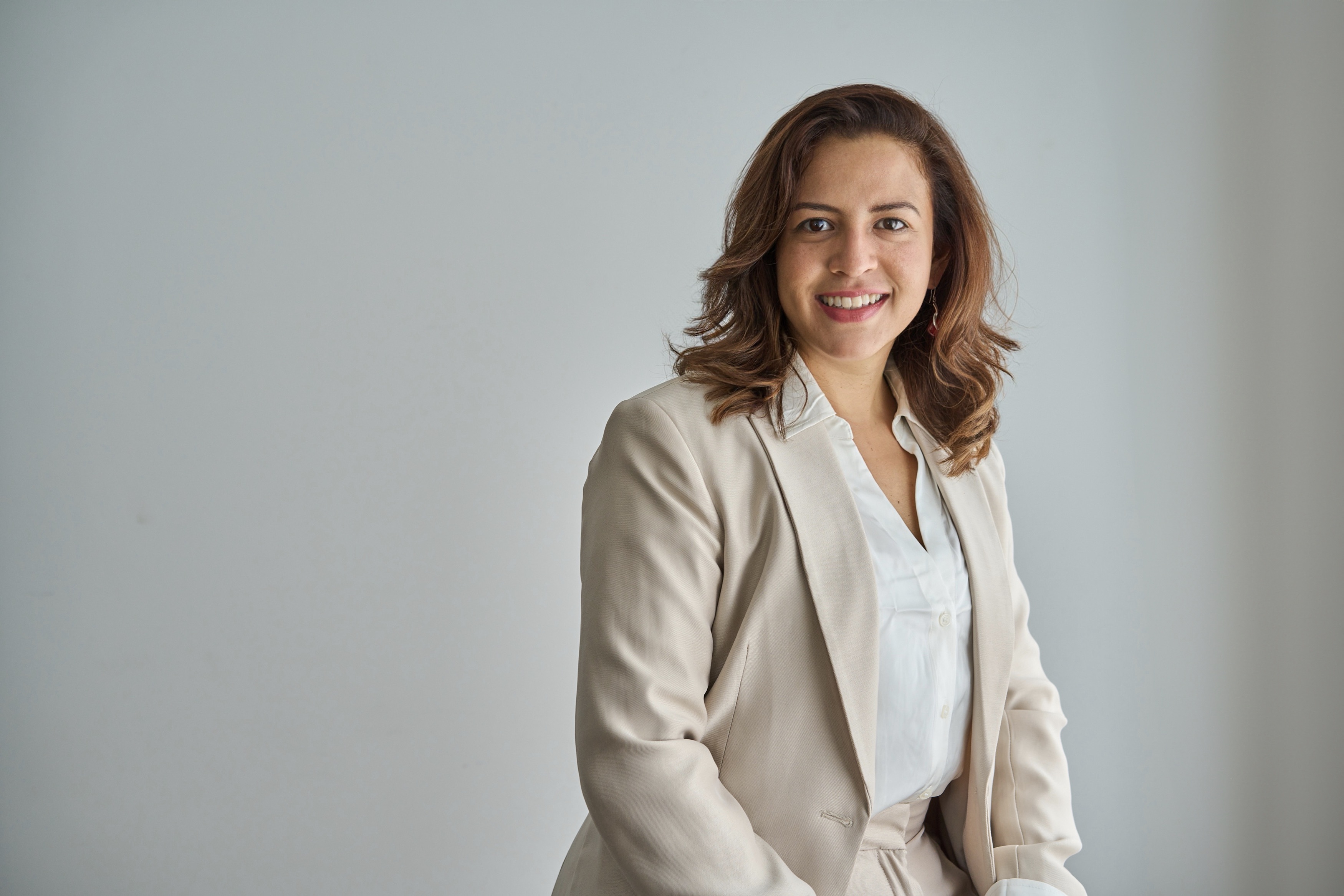 Luisana Milazzo in a beige suit, smiling